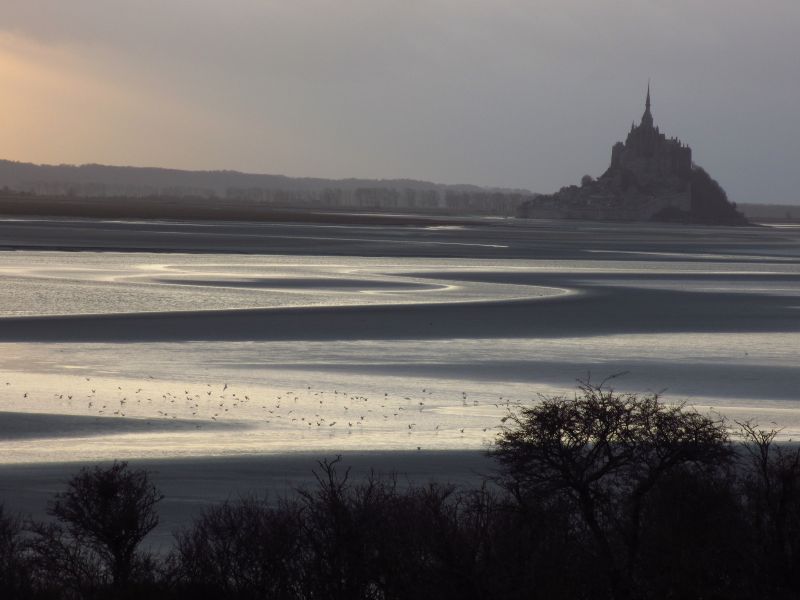 En Normandie, Le Mont Saint Michel avec la baie à marée basse . On y voit le reste de mer serpentée dans la baie