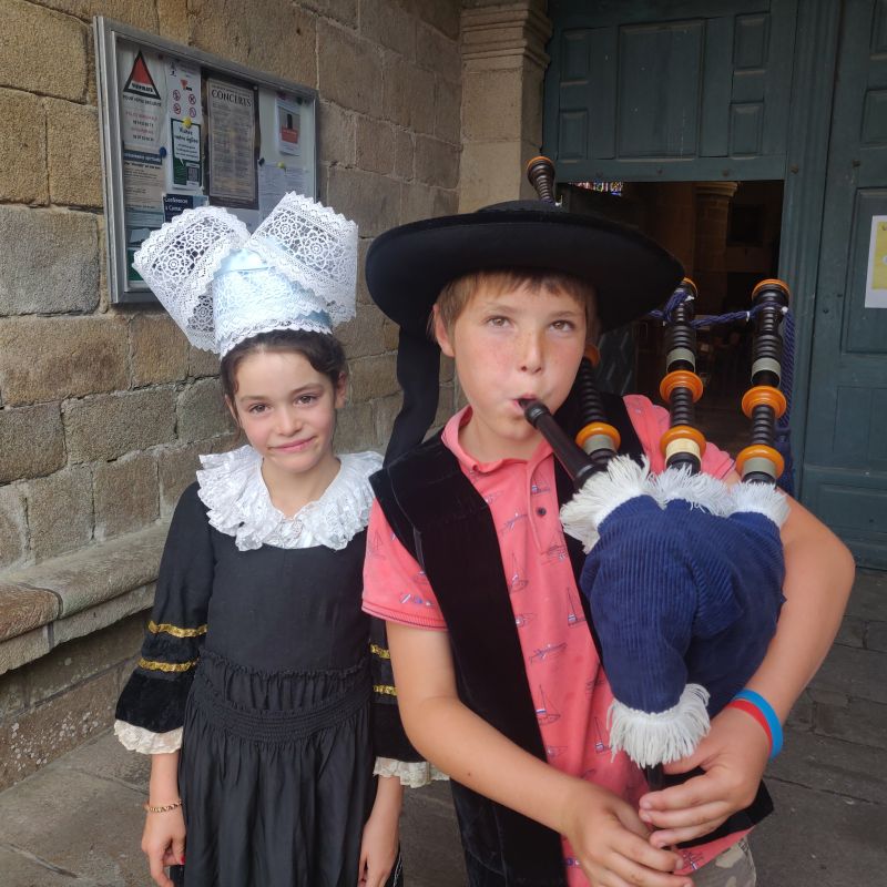 enfant  jouant de la cornemuse et enfant en tenue traditionnelle bretonne avec la coiffe en Finistère Sud