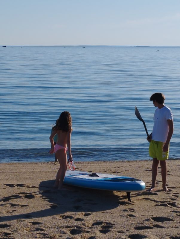 2 enfants au bord de la  mer en Finistère Sud s'apprettant à faire du paddle